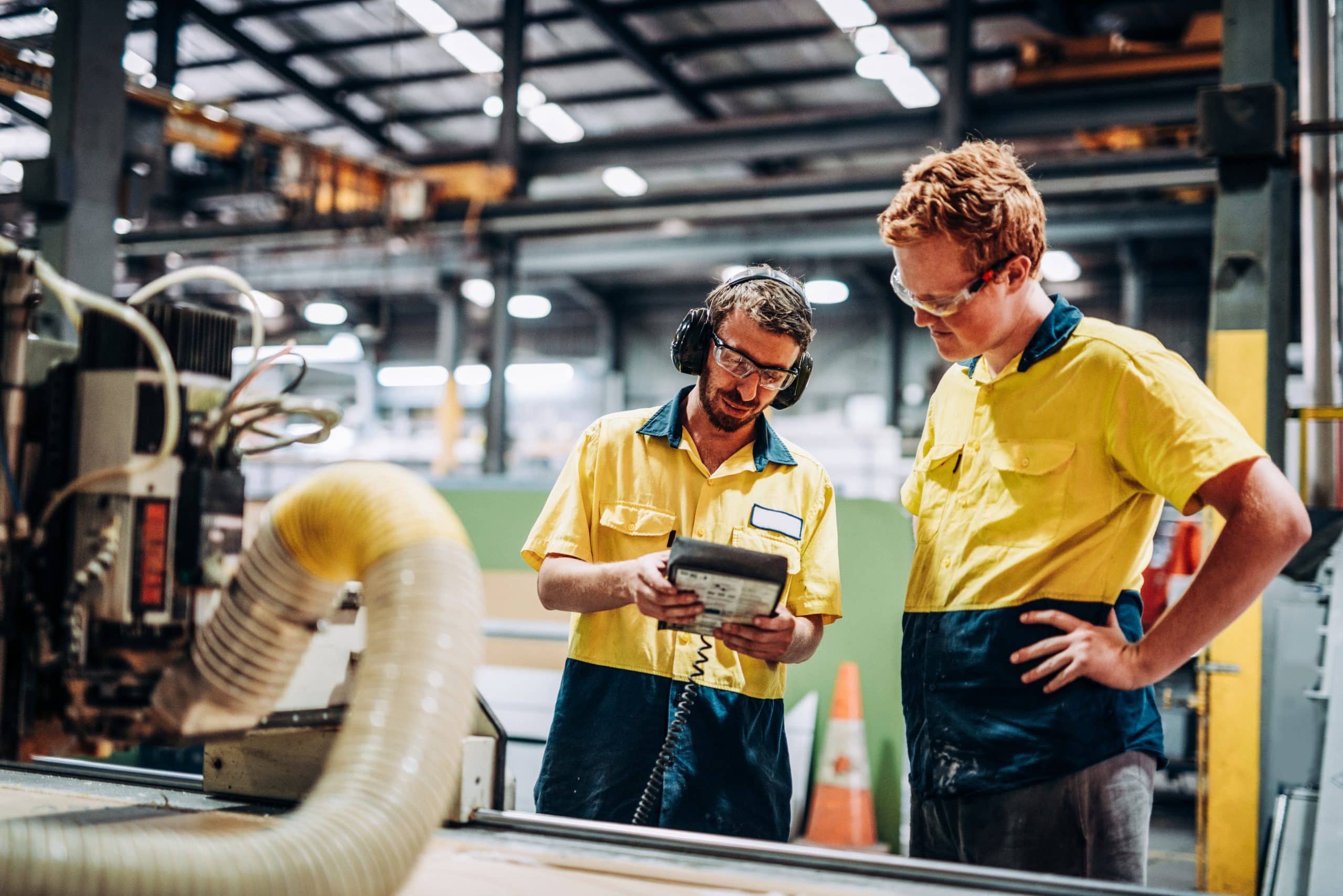 Trade apprentice and his supervisor in metal factory in Australia