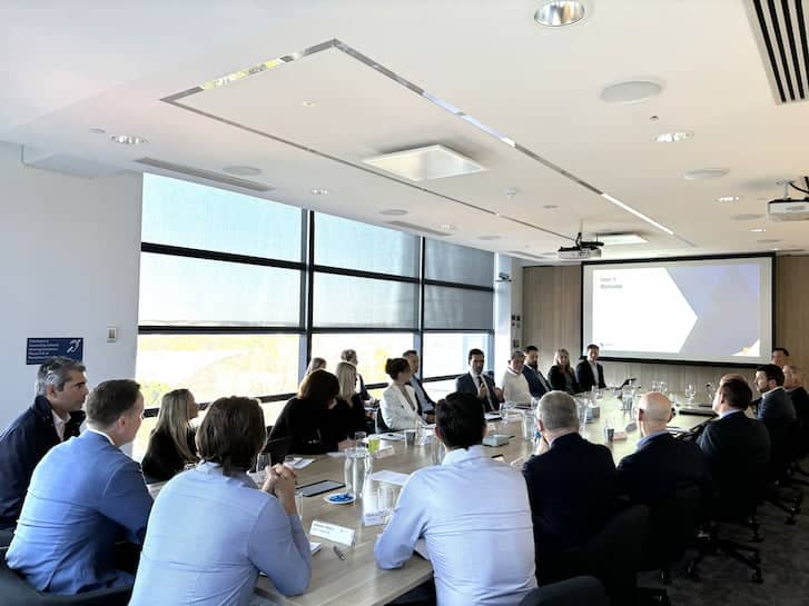 Several individuals seated at a conference table, actively participating in a meeting within a modern conference room.