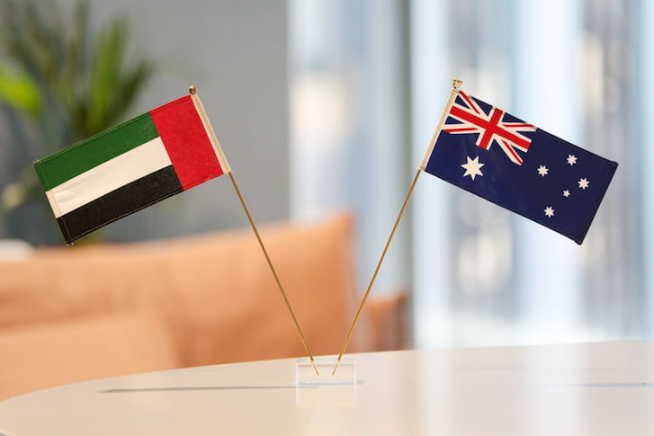 Two flags, one Australian and one UAE, displayed on a table, symbolising friendship and cooperation between the nations.