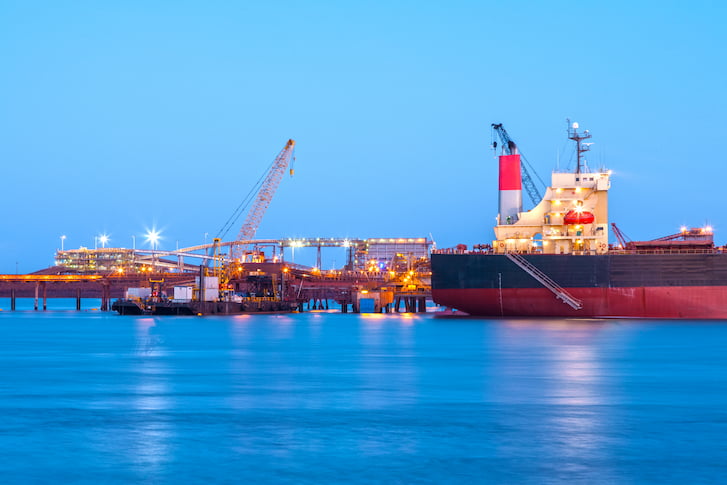 Port Hedland Western Australia, bulk carrier and floating crane in port at twilight.