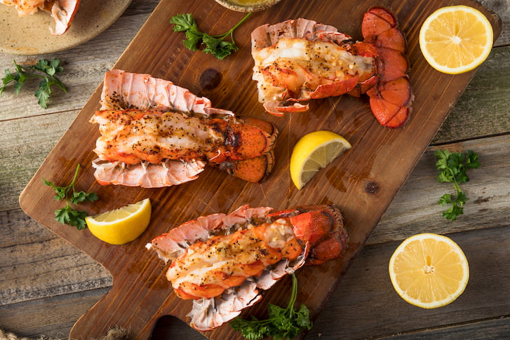 Lobster tails prepared on a wooden board.