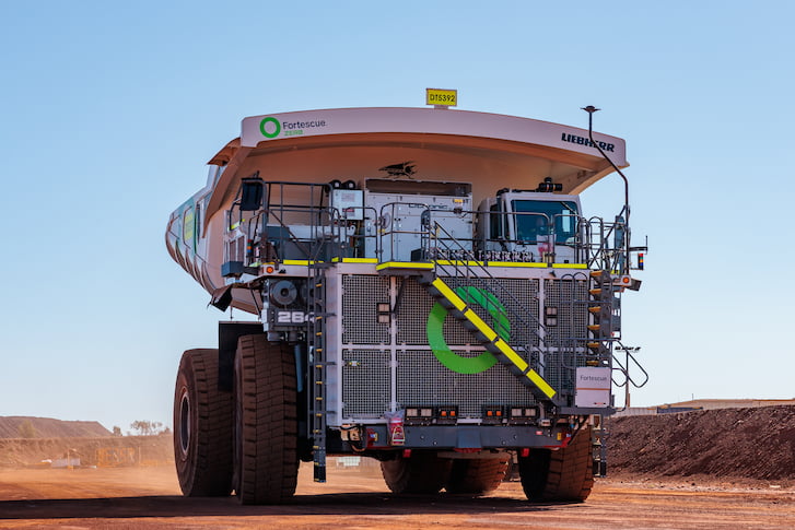 A large truck navigating a rugged dirt road, showcasing its robust design and off-road capabilities.