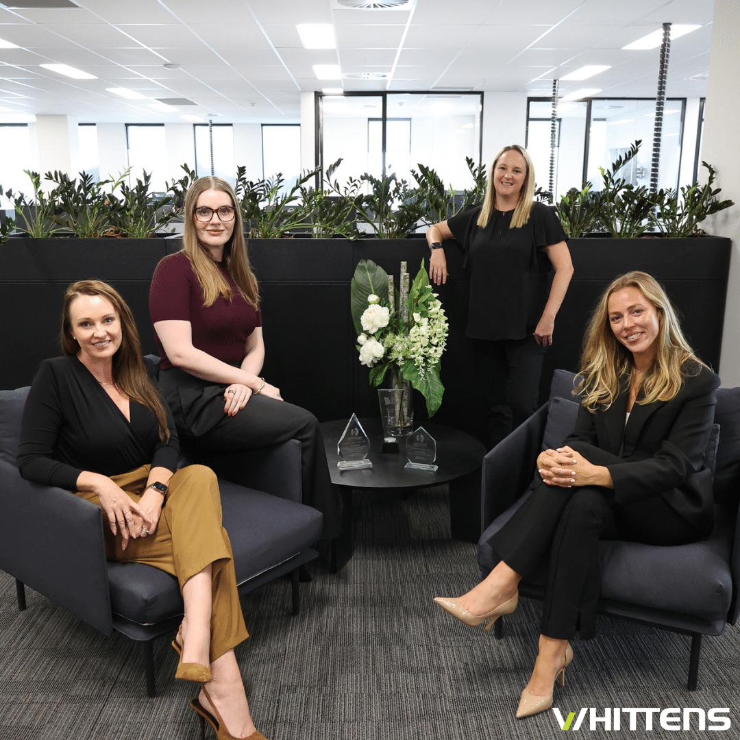  Four women seated on chairs in an office.
