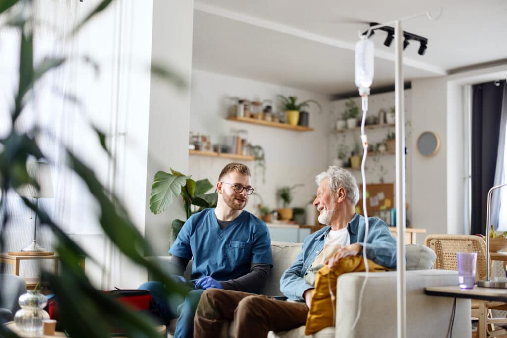 Senior man talking with his caregiver at home