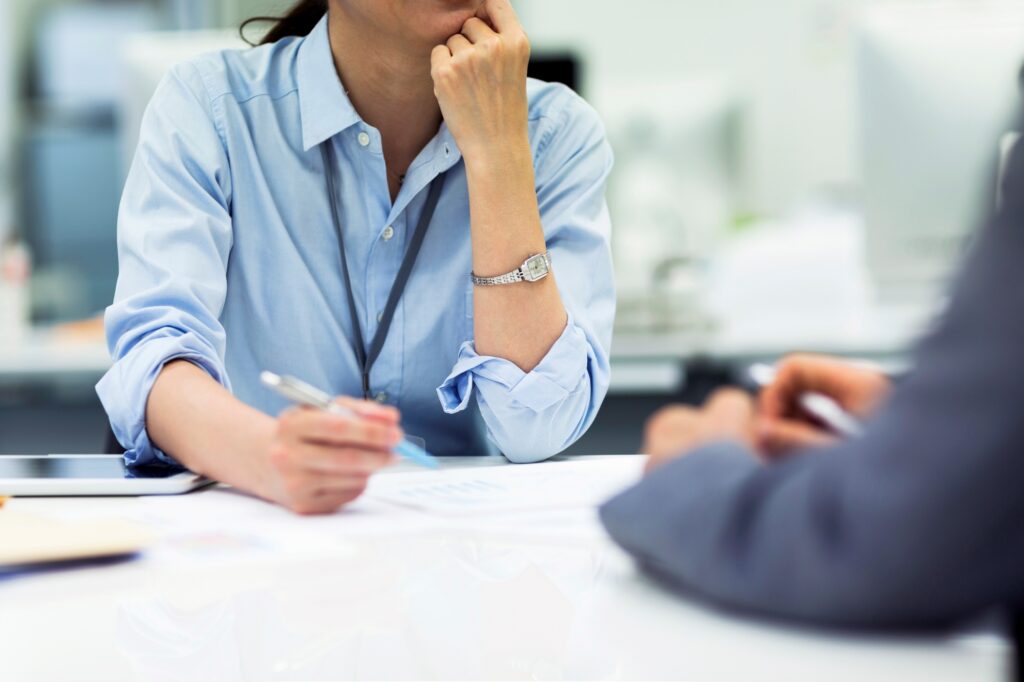 Manager meeting with an employee across a desk to discuss work issues, illustrating managing poor performance and workplace performance management conversations.