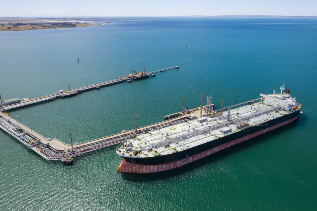 Aerial photo of oil tanker docked at a pier.