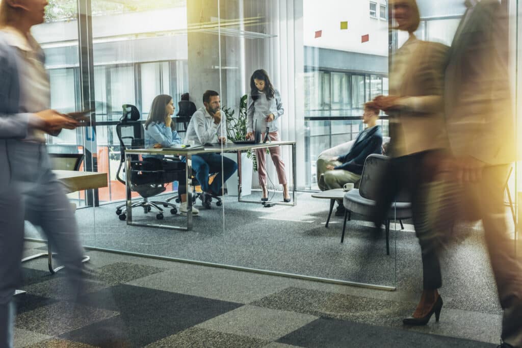 Employees collaborating in a modern office meeting space, representing workforce planning, business operations and workplace management.