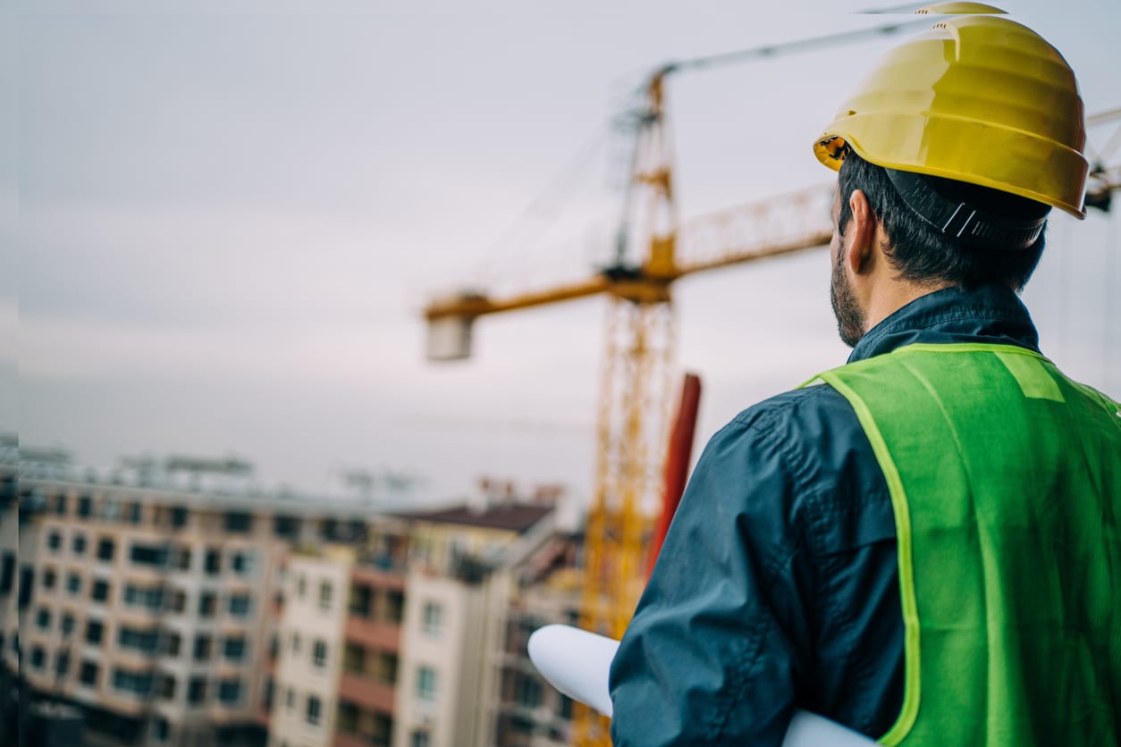 Construction worker in high-visibility gear overlooking a building site, highlighting the skills shortage in the construction industry.