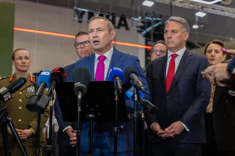 Premier Roger Cook standing at a press conference at Land Forces 2026. Standing to his left is Deputy Prime Minister Richard Marles.